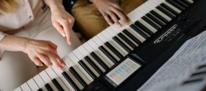 Two people playing keyboard together